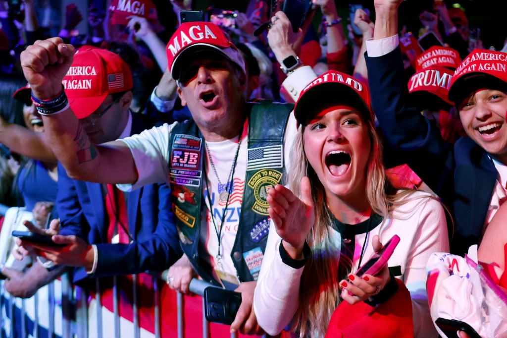 Supporters in red hats react to Fox News' announcement of Donald Trump's election as president at an event in West Palm Beach, Florida